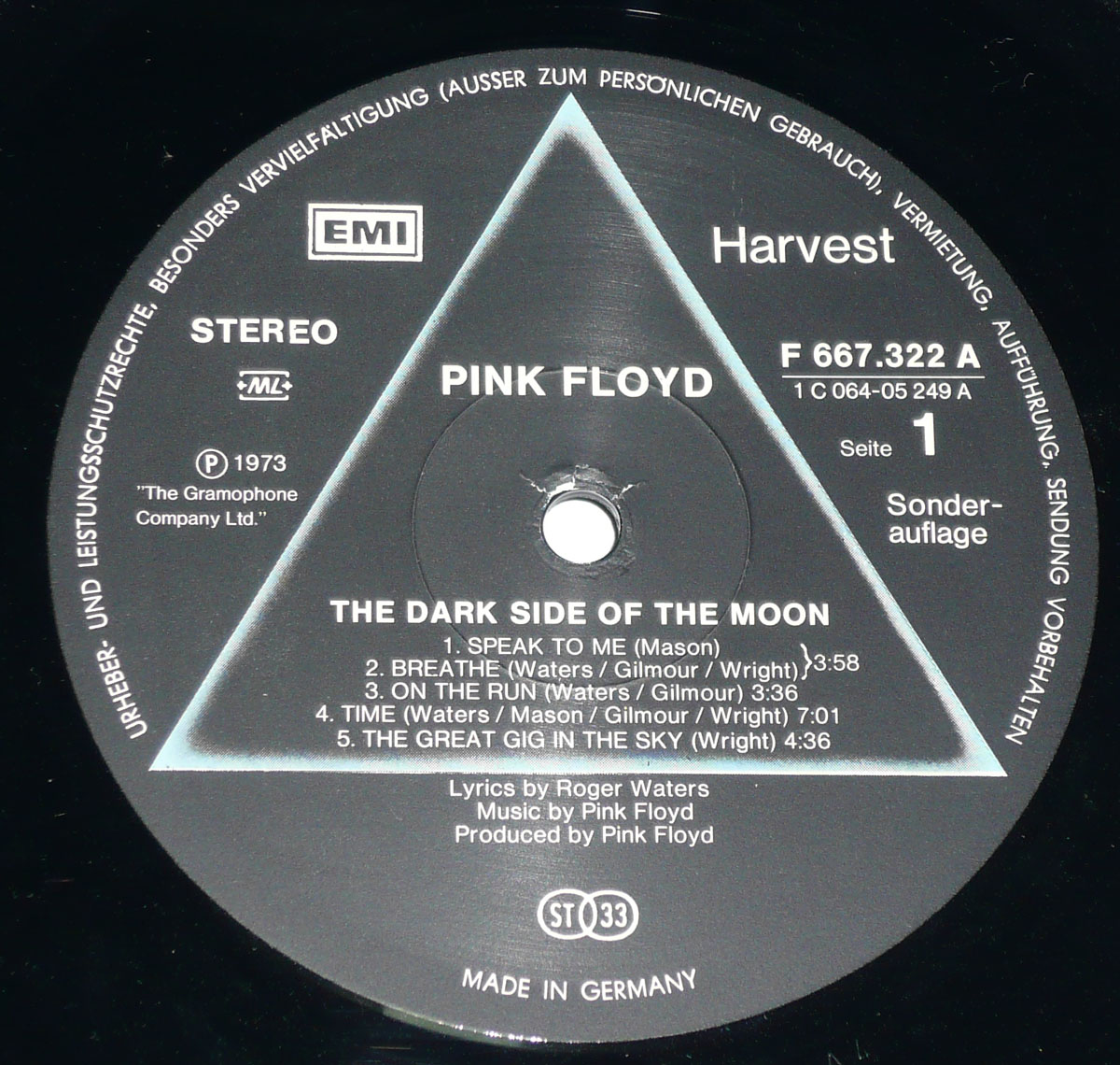 The record label of the Swiss version of Pink Floyd’s The Dark Side of the Moon, featuring a black circular background with the iconic prism and triangle design. The text includes "PINK FLOYD" and "THE DARK SIDE OF THE MOON," with track listings for Side 1: Speak to Me, Breathe, On the Run, Time, and The Great Gig in the Sky. The label includes the "Harvest" and "EMI" logos, copyright details from 1973, and the word "Sonderauflage" (Special Edition) indicating a unique release. Made in Germany, with German text detailing legal rights.